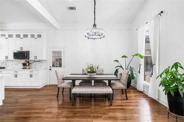 dining room featuring baseboards, a notable chandelier, visible vents, and dark wood finished floors