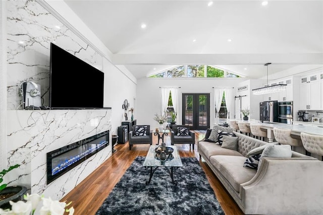 living room with wood finished floors, a high end fireplace, lofted ceiling, and recessed lighting