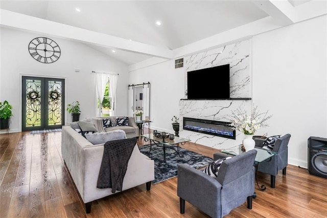 living area featuring lofted ceiling with beams, french doors, recessed lighting, and wood finished floors
