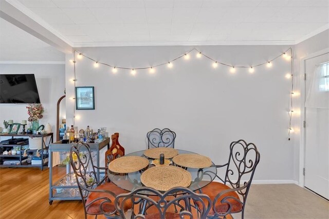 dining space with plenty of natural light, light wood-style flooring, and crown molding