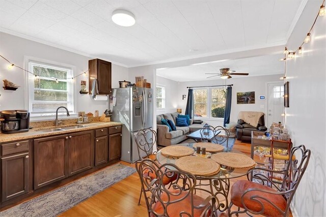 kitchen featuring ornamental molding, appliances with stainless steel finishes, a sink, and light stone counters