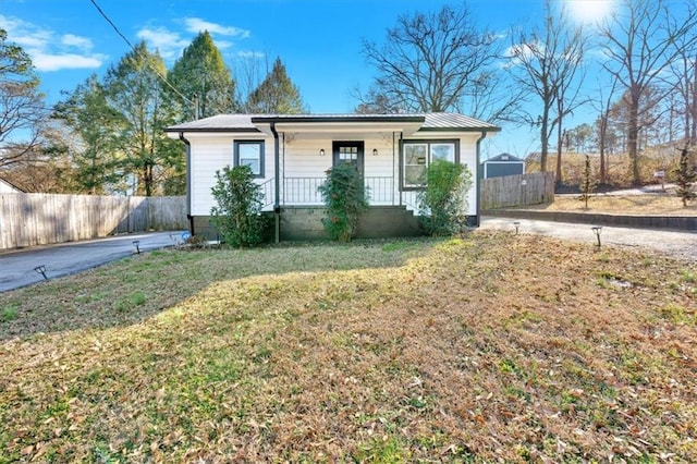 view of outdoor structure featuring fence and a porch