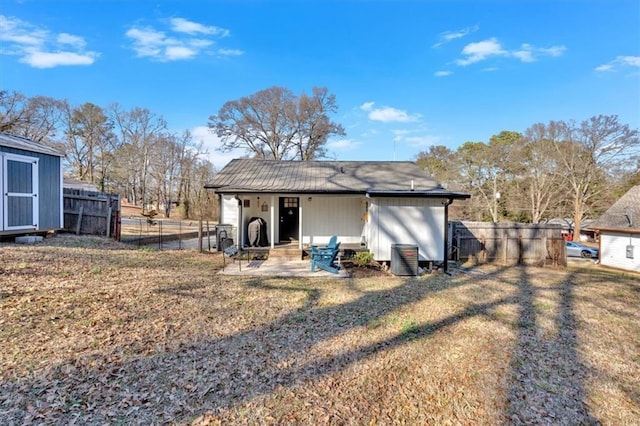 rear view of house with a yard, a fenced backyard, and an outdoor structure