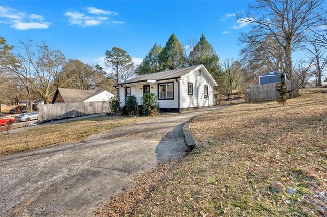 view of front of home with aphalt driveway and fence