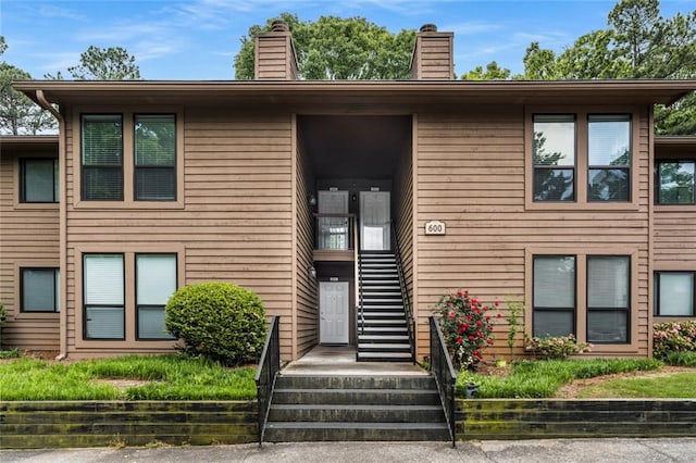 view of front of home featuring stairs and a chimney