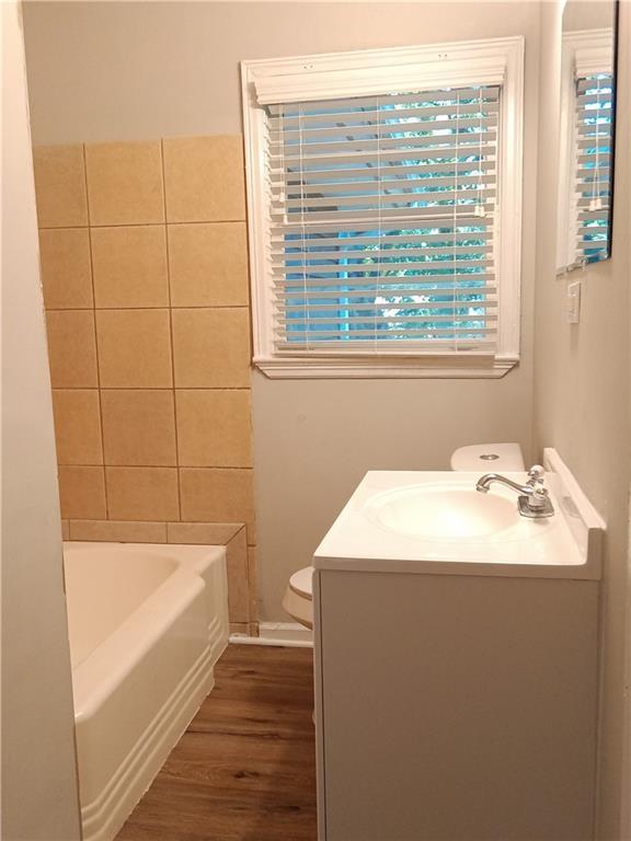 732 Vinson Pl SW, Atlanta, GA 30315 - bathroom with toilet, wood finished floors, a bath, and vanity