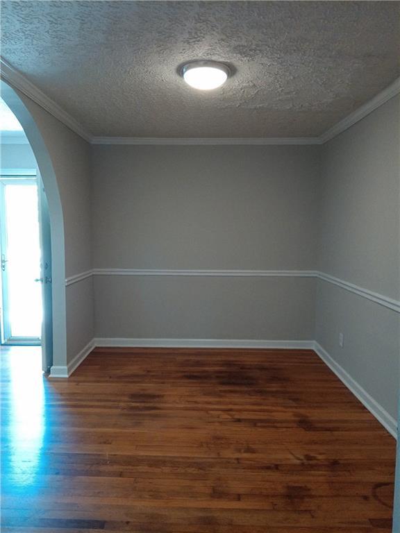 732 Vinson Pl SW, Atlanta, GA 30315 - empty room featuring arched walkways, wood finished floors, a textured ceiling, and baseboards