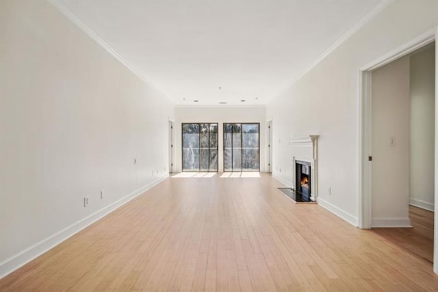 2921 Lenox Rd Unit 308, Atlanta, GA 30324 - unfurnished living room featuring ornamental molding, a warm lit fireplace, baseboards, and light wood-style floors