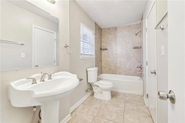 full bathroom with tile patterned flooring, tiled shower / bath combo, sink, and toilet