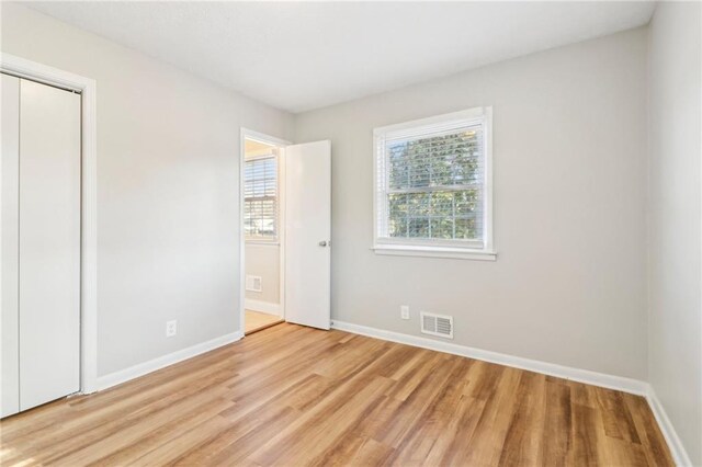 unfurnished bedroom with a closet, light hardwood / wood-style flooring, and a textured ceiling