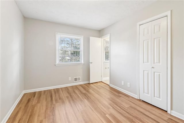 unfurnished bedroom featuring light wood-type flooring and a closet