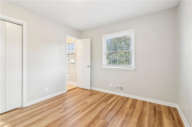 unfurnished bedroom with a closet and light hardwood / wood-style flooring