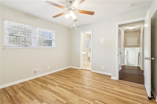 unfurnished bedroom featuring ensuite bathroom, ceiling fan, and light hardwood / wood-style floors