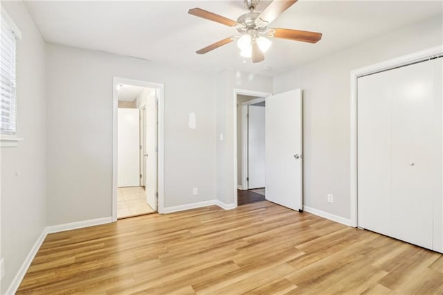 unfurnished bedroom with a closet, ensuite bathroom, ceiling fan, and light hardwood / wood-style flooring