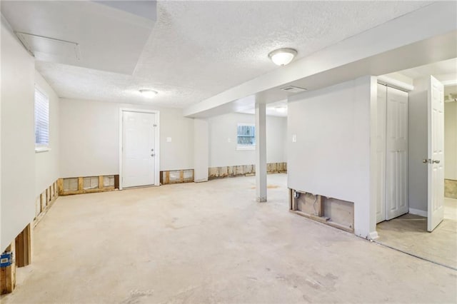 basement featuring a textured ceiling and a wealth of natural light