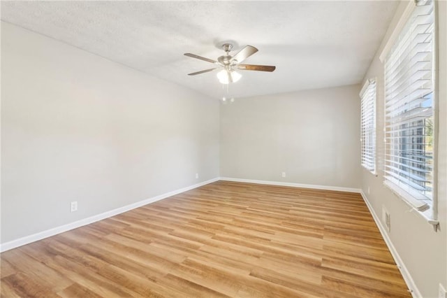 empty room with ceiling fan and light wood-type flooring