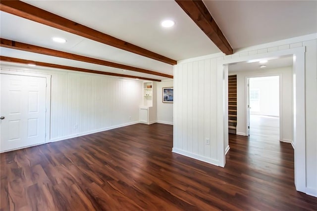 unfurnished living room with dark hardwood / wood-style flooring and beamed ceiling