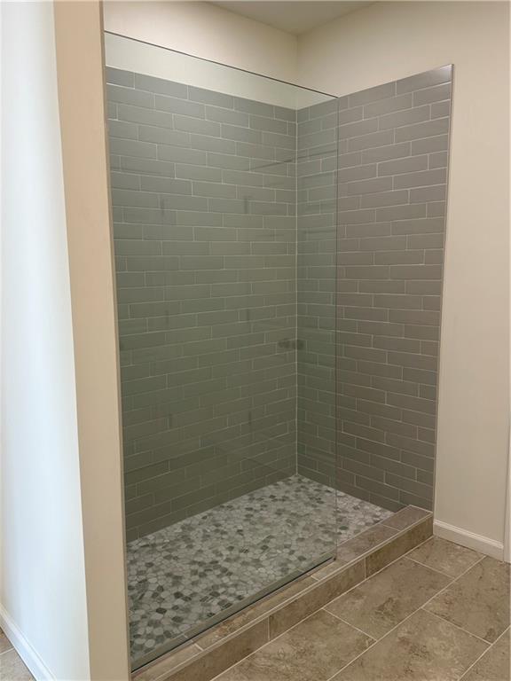 bathroom featuring a tile shower and vanity