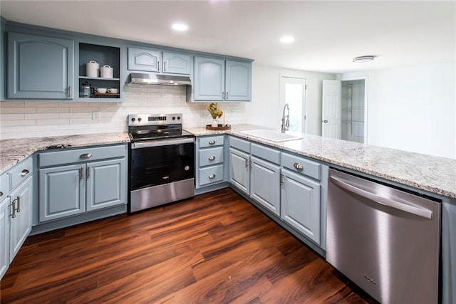 kitchen featuring kitchen peninsula, dark hardwood / wood-style floors, stainless steel appliances, backsplash, and sink