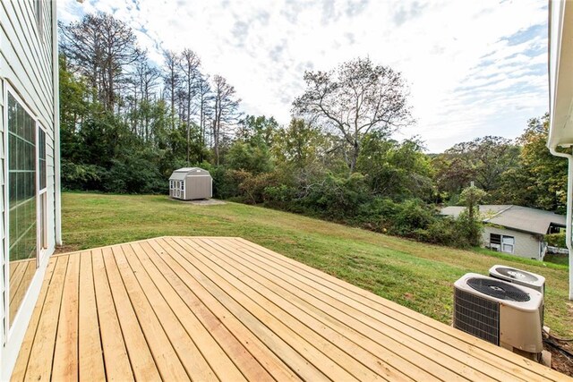 rear view of house featuring a lawn and a shed