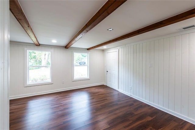 unfurnished room featuring dark wood-type flooring and beamed ceiling