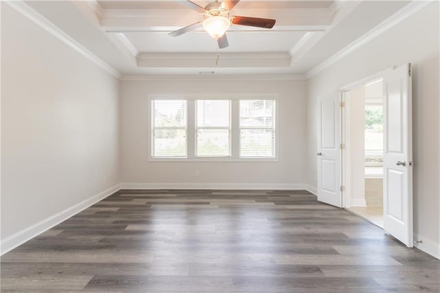 spare room featuring healthy amount of natural light, a tray ceiling, a ceiling fan, crown molding, and wood finished floors
