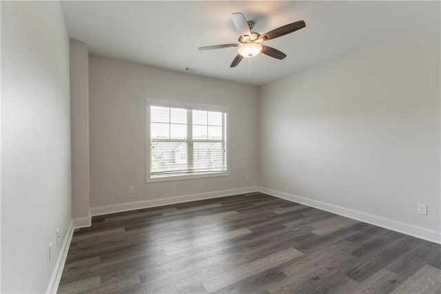empty room with dark wood-type flooring, ceiling fan, and baseboards