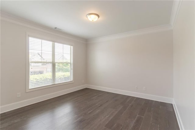 spare room featuring ornamental molding, dark wood-type flooring, and baseboards