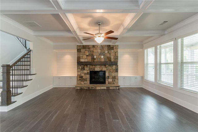 unfurnished living room with dark wood-type flooring, a ceiling fan, baseboards, a stone fireplace, and stairs