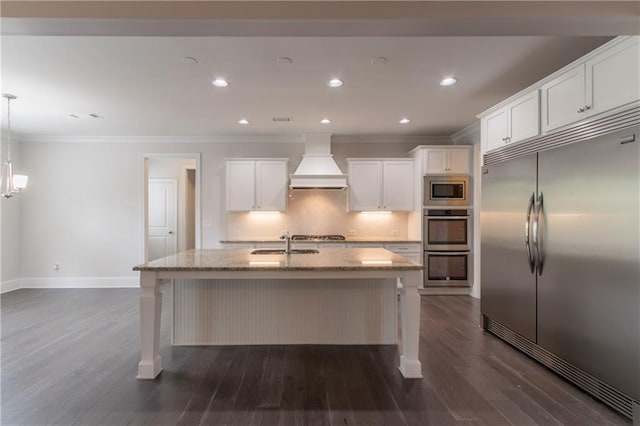 kitchen with built in appliances, premium range hood, crown molding, dark wood-style floors, and baseboards
