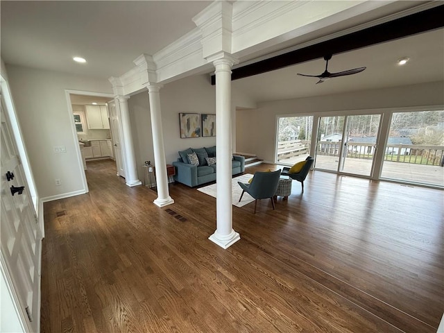 living room featuring decorative columns, dark hardwood / wood-style floors, and ceiling fan