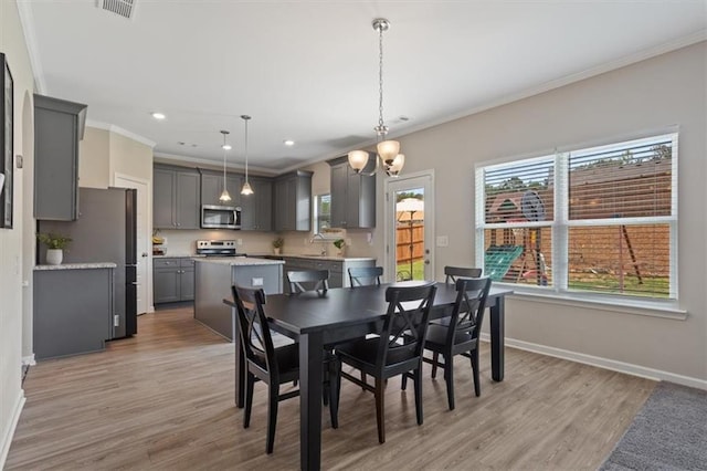dining area with crown molding, baseboards, light wood-style floors, a chandelier, and recessed lighting