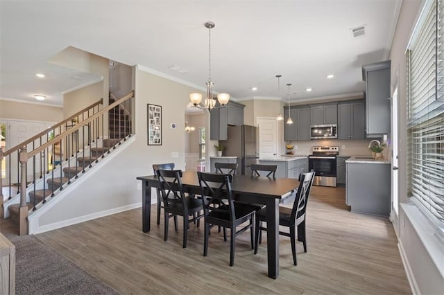 dining room with stairs, crown molding, light wood-style flooring, baseboards, and recessed lighting