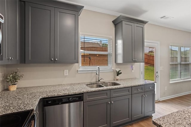 kitchen with stainless steel dishwasher, a sink, light wood-style flooring, ornamental molding, and range