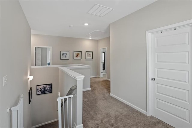 hallway featuring an upstairs landing, carpet flooring, attic access, baseboards, and recessed lighting
