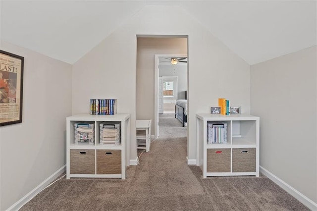 recreation room featuring carpet, vaulted ceiling, a ceiling fan, and baseboards