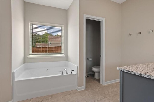 full bath with toilet, a garden tub, tile patterned floors, and baseboards