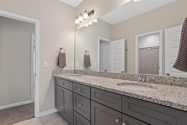 bathroom with double vanity and baseboards