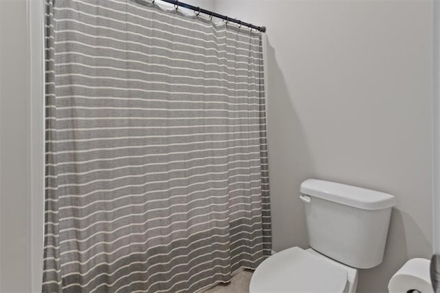 full bath featuring toilet and a shower with curtain