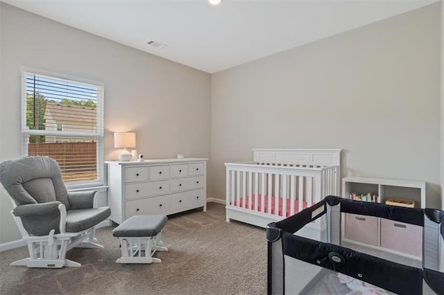 carpeted bedroom with baseboards and a crib