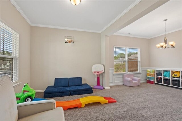 game room with ornamental molding, a chandelier, carpet flooring, and wainscoting
