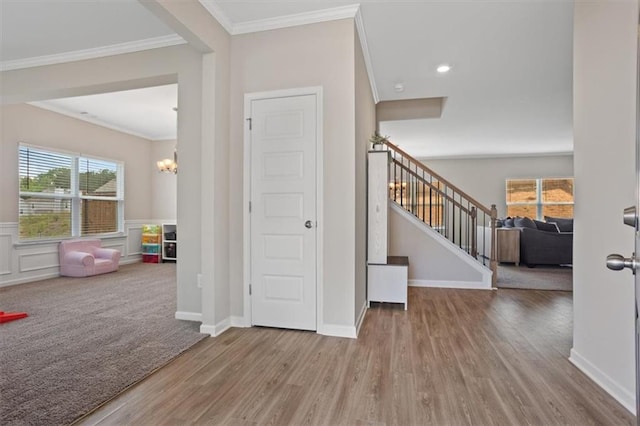entrance foyer with wood finished floors, a chandelier, ornamental molding, stairway, and recessed lighting