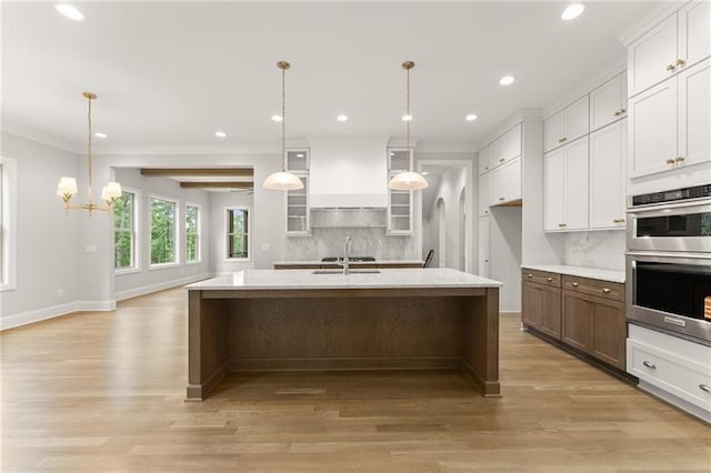 4860 Grandview Ct, Flowery Branch, GA 30542 - kitchen featuring stainless steel double oven, decorative backsplash, ornamental molding, glass insert cabinets, and a kitchen island with sink