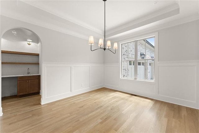 4860 Grandview Ct, Flowery Branch, GA 30542 - unfurnished dining area with a tray ceiling, crown molding, a decorative wall, light wood-style floors, and a chandelier