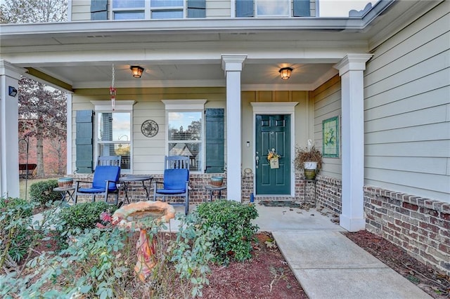 view of exterior entry featuring covered porch