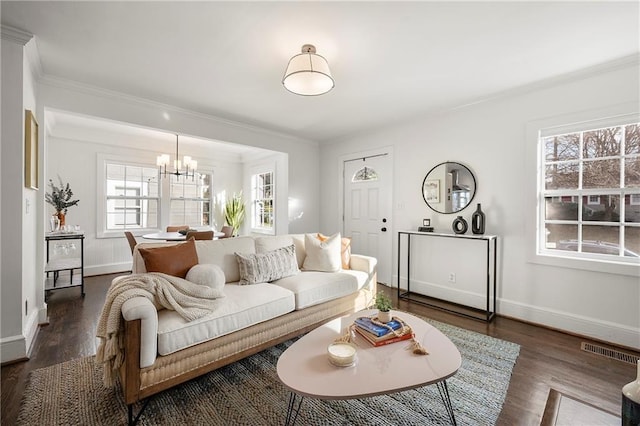 living room with dark hardwood / wood-style flooring, a notable chandelier, and ornamental molding