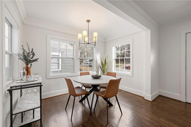 dining area featuring an inviting chandelier, dark wood-type flooring, baseboards, and ornamental molding