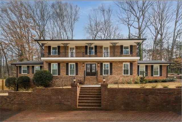 view of front of property with a balcony and brick siding