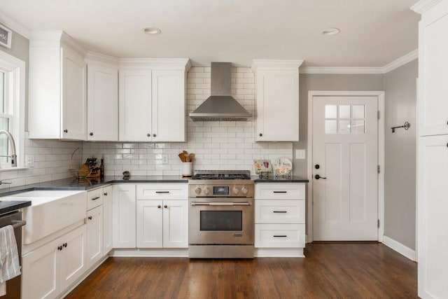 kitchen with stainless steel appliances, dark wood-style flooring, white cabinetry, and wall chimney exhaust hood