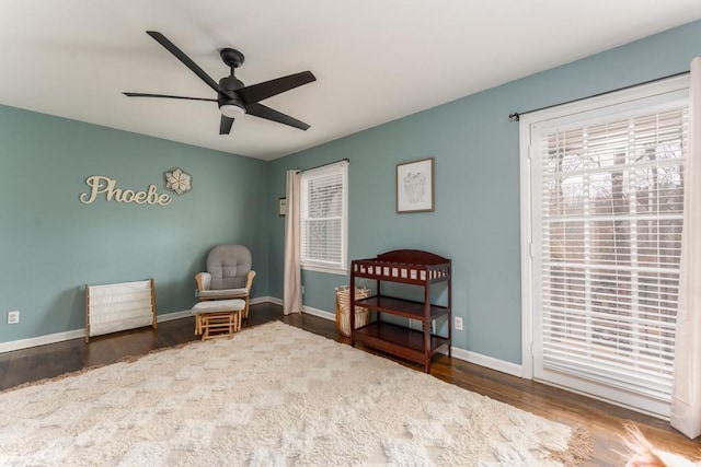 living area featuring ceiling fan, wood finished floors, and baseboards